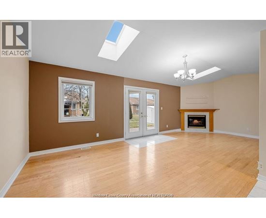 A spacious room with a fireplace and a skylight.
