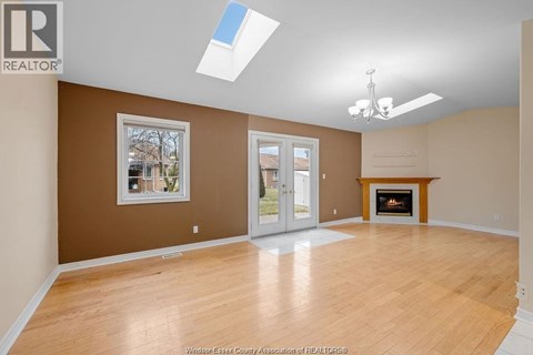 A spacious room with a fireplace and a skylight.