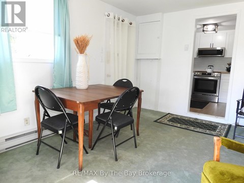 A dining room with a table and chairs.