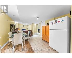 A kitchen with a white fridge and a dining table with chairs.