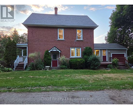 A red brick house with a white door and windows.