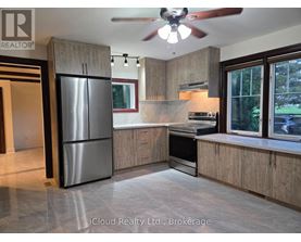 A modern kitchen with wooden cabinets and a stainless steel refrigerator.