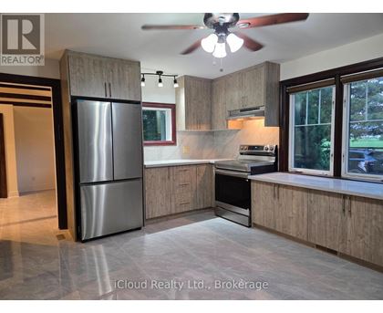 A modern kitchen with wooden cabinets and a stainless steel refrigerator.