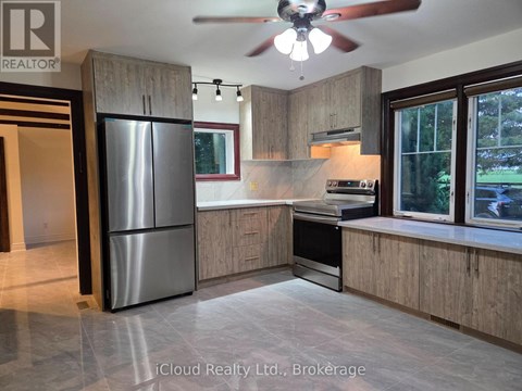 A modern kitchen with wooden cabinets and a stainless steel refrigerator.