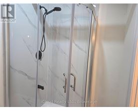 A glass shower door with a handle and a hose attached to it.