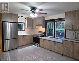 A kitchen with wooden cabinets and a stainless steel refrigerator.