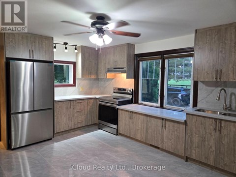 A kitchen with wooden cabinets and a stainless steel refrigerator.