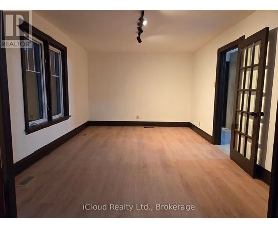 A room with wooden flooring and a ceiling light fixture.