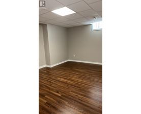 A room with wooden flooring and white walls.