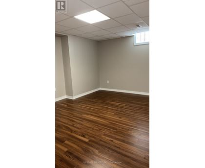 A room with wooden flooring and white walls.