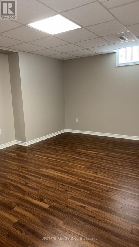 A room with wooden flooring and white walls.