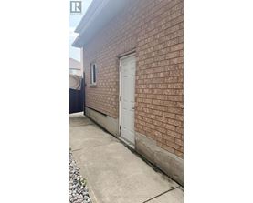 A white door is on the side of a brick building.