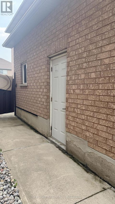 A white door is on the side of a brick building.