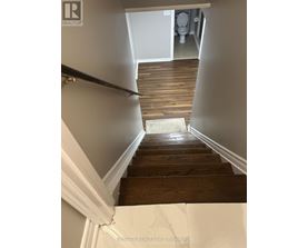 A wooden staircase leading to a bathroom.