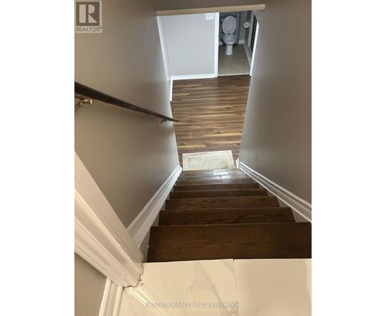 A wooden staircase leading to a bathroom.