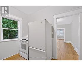 A white refrigerator in a kitchen with a window.