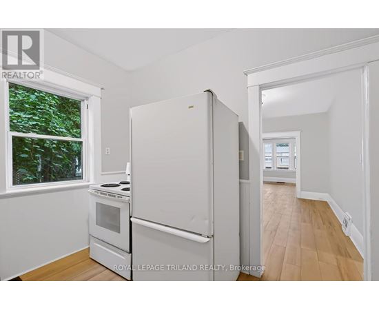 A white refrigerator in a kitchen with a window.