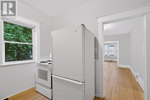 A white refrigerator in a kitchen with a window.