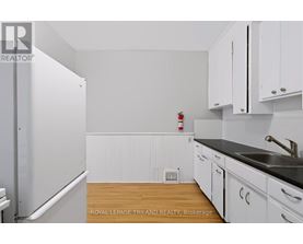 A kitchen with white cabinets and a black countertop.