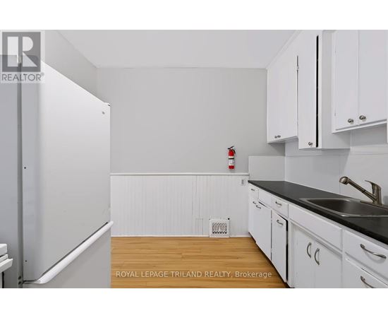 A kitchen with white cabinets and a black countertop.