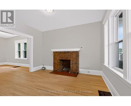 A room with a fireplace and wooden floors.
