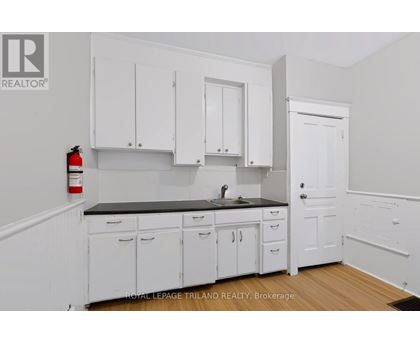A kitchen with white cabinets and a black countertop.