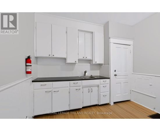A kitchen with white cabinets and a black countertop.