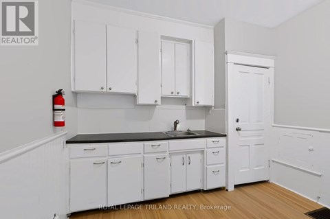 A kitchen with white cabinets and a black countertop.