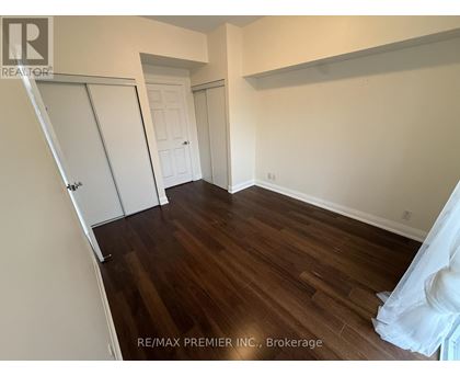 A room with wood flooring and a white door.