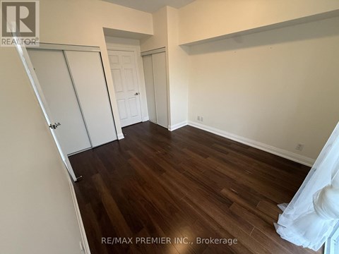A room with wood flooring and a white door.