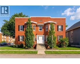 A red brick house with a white door and windows.