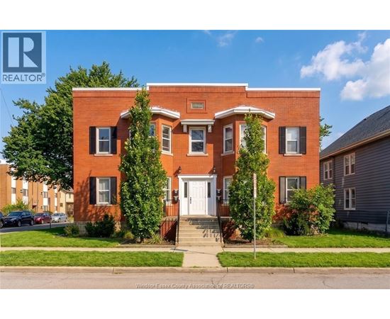 A red brick house with a white door and windows.