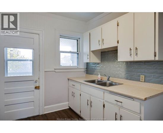 A kitchen with white cabinets and a sink.
