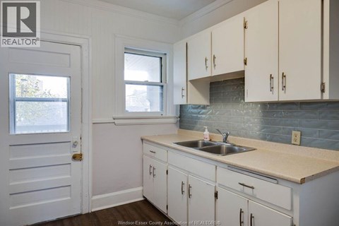 A kitchen with white cabinets and a sink.