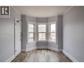 A room with a door, a window and a window seat.