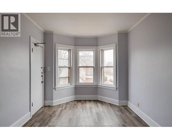 A room with a door, a window and a window seat.
