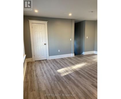 A room with a white door and grey walls.