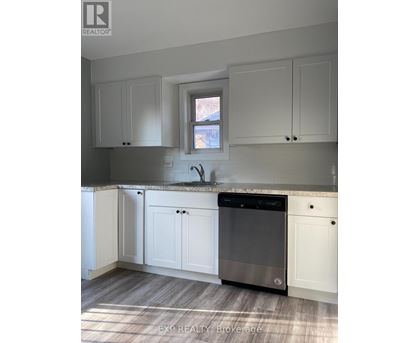 A kitchen with white cabinets and a black dishwasher.