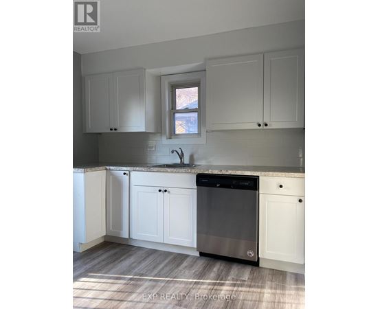 A kitchen with white cabinets and a black dishwasher.