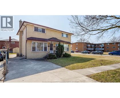 A two-story house with a brown roof and a white window is for sale.