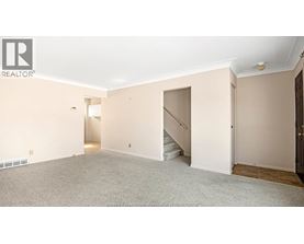 A spacious room with a staircase leading to another level.