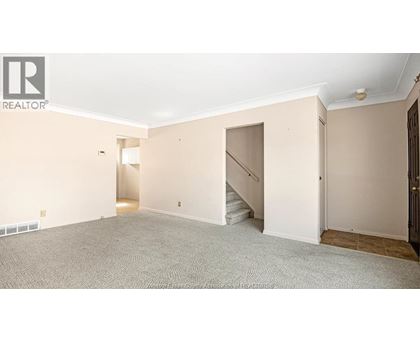A spacious room with a staircase leading to another level.