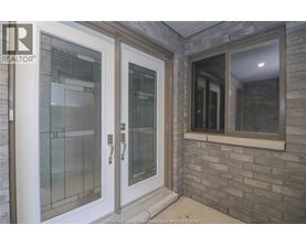 A glass door with a handle is on the left and a window with a white frame is on the right.