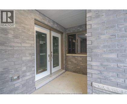 A grey stone wall with a glass door and a window.