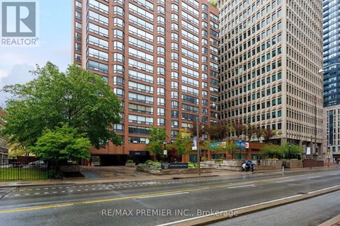 A street view of a city with buildings, trees, and a car on the road.