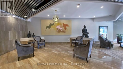 A living room with a grey couch, a coffee table, and a painting on the wall.