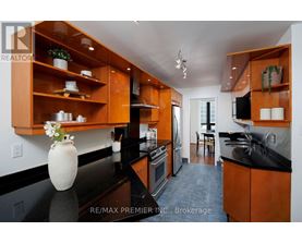 A kitchen with wooden cabinets and black countertops.