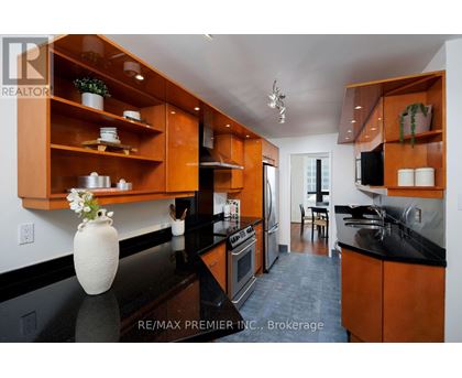 A kitchen with wooden cabinets and black countertops.