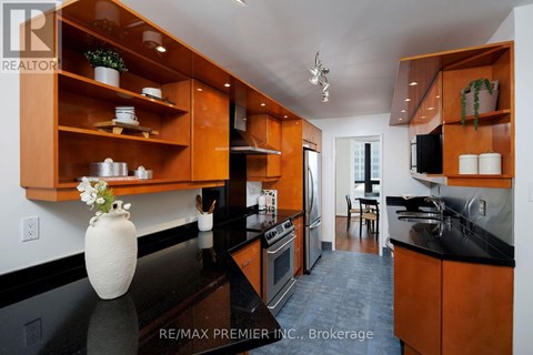 A kitchen with wooden cabinets and black countertops.