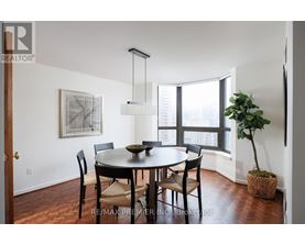 A dining room with a table and chairs.
